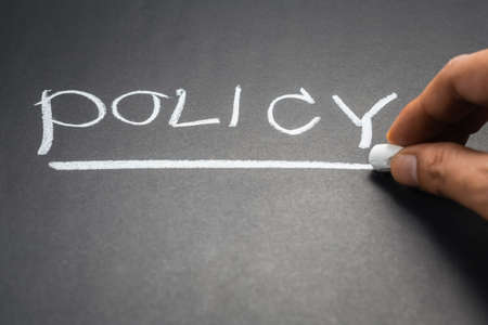 Hand writing Policy topic on chalkboardの写真素材