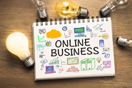 Online Business and drawing on notebook with glowing light bulbsの写真素材