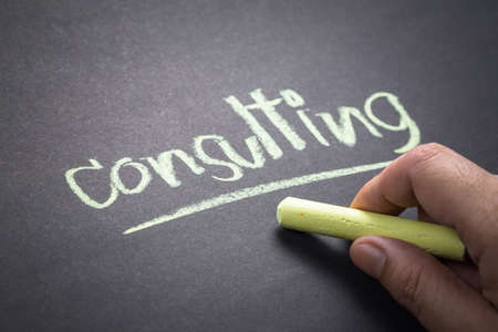 Hand writing Consulting topic on chalkboard