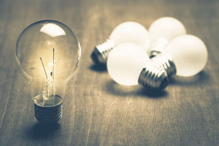 Individual light bulb glowing out of the group