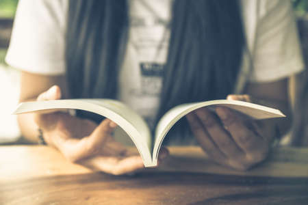 Closeup woman's hand open the book to readの写真素材