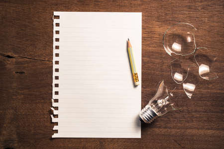 Paper and pencil with broken light bulb for writing conceptの写真素材