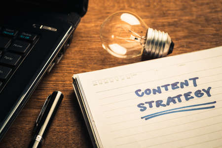 Content Strategy plan on notebook with glowing light bulbの写真素材