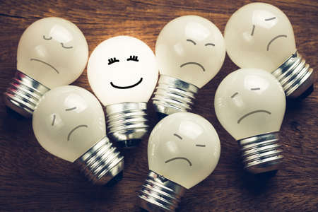 One light bulb glowing in a group with smile face