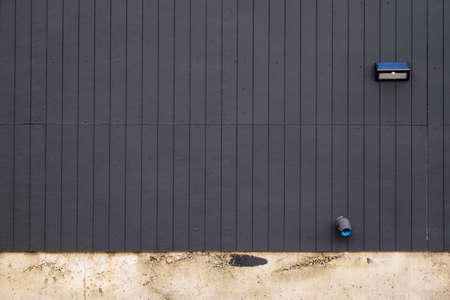 Black striped wall with lamp and water pipeの写真素材