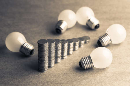 Heap coins stair with many small light bulbsの写真素材