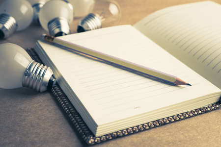 Pencil on notebook with many light bulbs, collect idea for good writingの写真素材