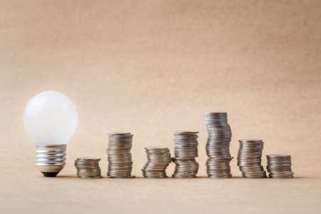 Budget idea concept, heap of coins with small light bulbの写真素材