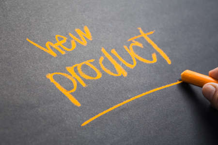 Closeup hand write a topic New Product on chalkboardの写真素材