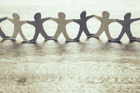 Human chain paper on wood tableの写真素材