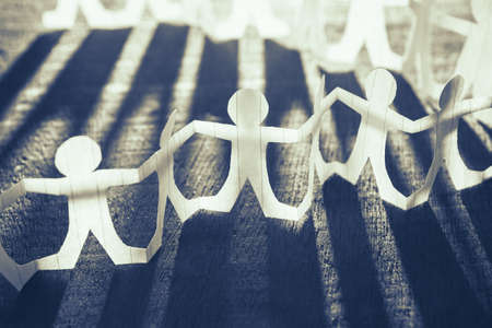 Row of human chain paper in light and shadowの写真素材