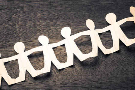 Human chain paper on wood backgroundの写真素材