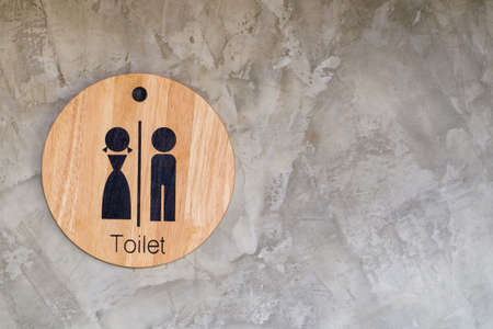 Toilet circle wood sign on concrete wall