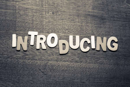 Introducing word  by wood letters on wood background