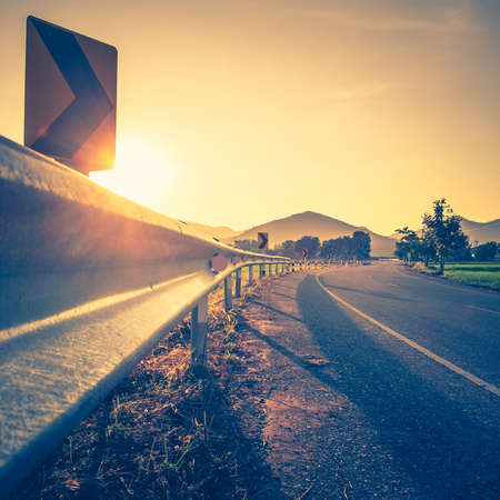 Curve road to the mountain at sunset in countryside, filter effect in retro color style