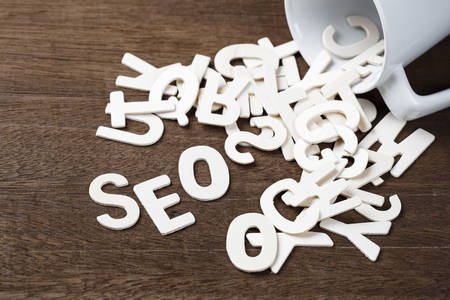 Wood letters spill out of a cup as SEO word