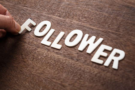 Hand arrange wood letters as FOLLOWER wordの写真素材