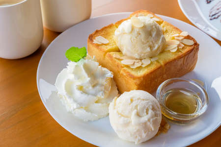 Honey toast topped with vanilla ice cream and syrupの写真素材