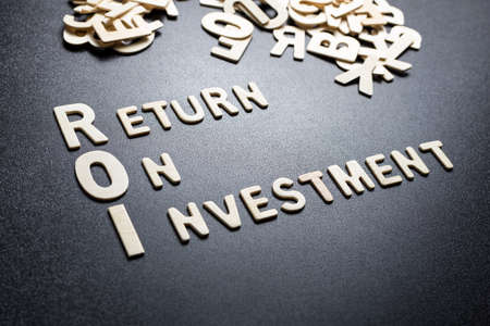 ROI or Return On Investment text by wood letters on black backgroundの写真素材