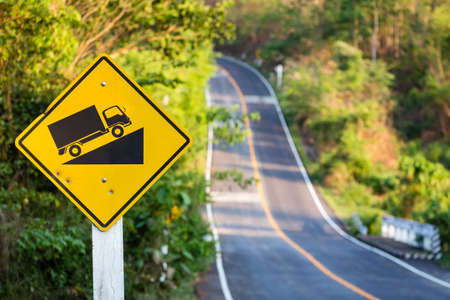 Steep grade traffic sign on the roadside, uphill asphalt road in countrysideの写真素材