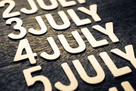 4th of July (wood letters) in running date of July month on wood backgroundの写真素材
