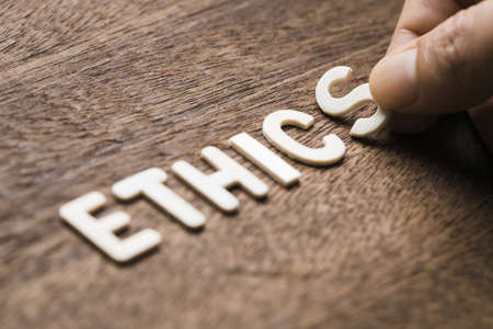 Closeup hand arrange wood letters as ETHICS wordの写真素材