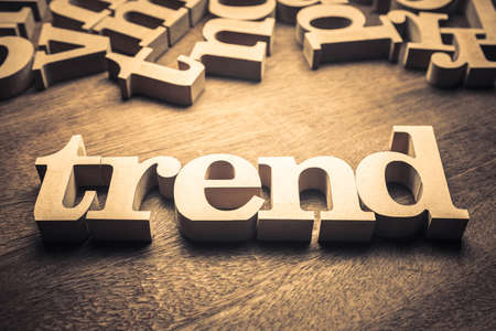 TREND wood word with scattered letters on wood background