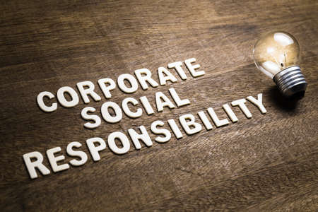 Corporate Social Responsibility or CSR, text with glowing light bulb as creativity and success idea