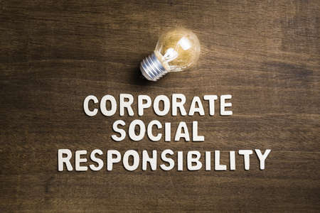 Corporate Social Responsibility or CSR, text with glowing light bulb as creativity and success idea