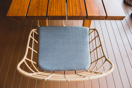 Metal chair binding by plastic stripe on frame with blue cushion at wood terrace outside the houseの写真素材