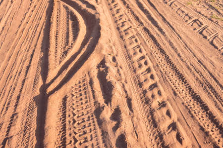 Many kinds of vehicle wheel tracks (car, tractor, motorcycle and bicycle) on dirt road, pattern of...