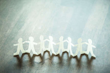 Paper human team stand on the clear wood tableの写真素材