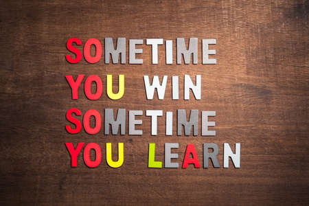 Motivation quotation (Sometimes You Win, Sometimes You Learn) arranged by wood letters on wood...