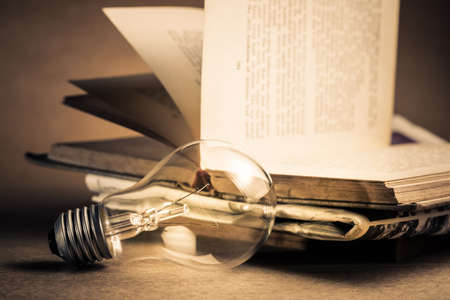 Light bulb with pile of old book for reading or knowledge concept