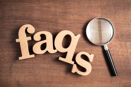 FAQs topic by wood letters with magnifying glass on wood backgroundの写真素材