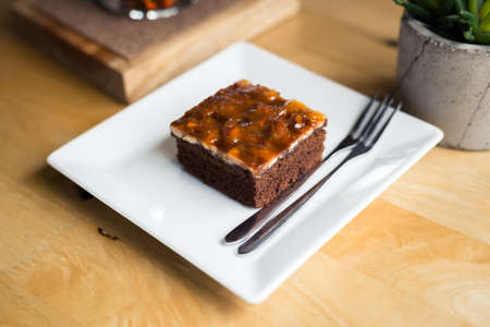 Small piece of brownie cake in white plate on wood tableの写真素材