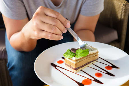 Closeup woman going to eat the cappuccino cake on the white plate