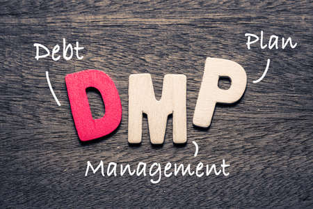 DMP wooden alphabets on wood background with text acronym (Debt Management Plan)