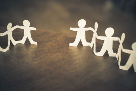 Two paper human chains disconnect or loosing doll in a role of team, teamwork or connection concept