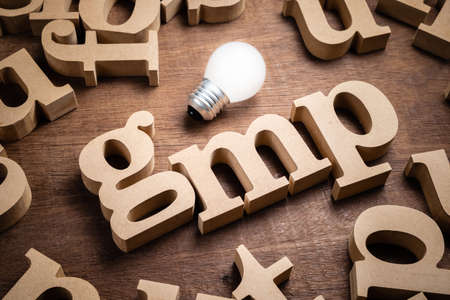 GMP wood alphabet in scattered letters with light bulb, abbreviation of Good Manufacturing Practiceの写真素材