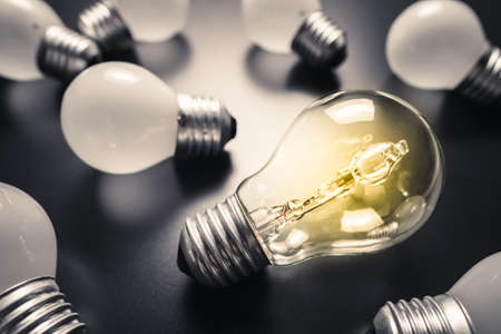 Different light bulb glow among the similar white bulbs