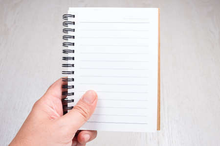 Hand with the small notebook show the empty space for textの写真素材