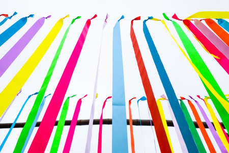 Closeup colorful ribbons hanging outdoor in the park as decoration for festive event, abstract...