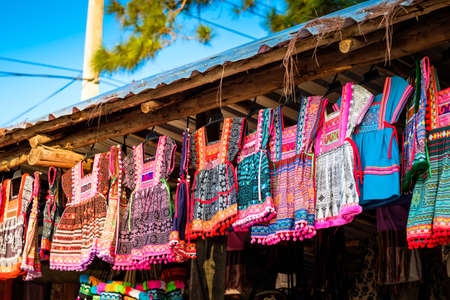 Colorful dress of Thai hill tribe style hanged for sale to the tourists at souvenir shop in local market, Northern of Thailandの写真素材
