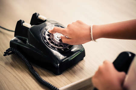 Closeup child hand dial numbers on the old telephoneの写真素材