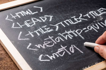 Closeup hand writing computer source code word with chalk on the blackboard
