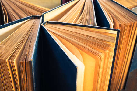 Closeup antique old books that stand on the table and show the yellowed paper of pagesの写真素材