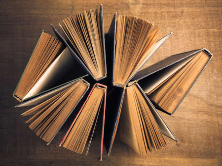 Antique old books that stand on the table with view from above to show the yellowed paper of pages and old conditionの写真素材
