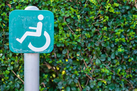 Handicapped icon signpost within public park area