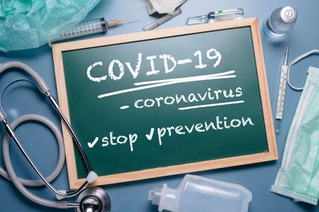 Covid-19 or coronavirus concept text on chalkboard placed on the table with many medical equipments